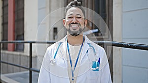 Young latin man doctor smiling confident standing at hospital