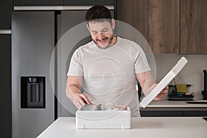 Young latin man opening his weekly delivery of fish in an EPS isothermal box.