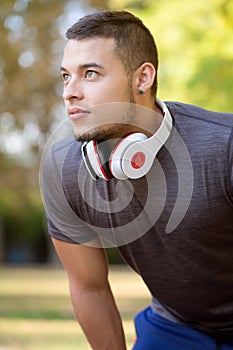 Young latin man runner looking up thinking running jogging sports training fitness workout portrait format