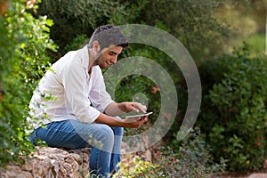 Young latin man searching internet coverage outdoor,