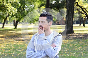 Young latin man thoughtful in a park.