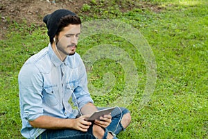Young latin man using tablet outdoors