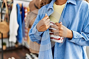 Young latin robber woman stealing handbag at clothing store