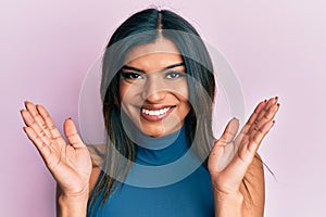 Young latin transsexual transgender woman with hands over face smiling with a happy and cool smile on face