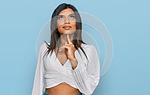 Young latin transsexual transgender woman wearing casual clothes thinking concentrated about doubt with finger on chin and looking