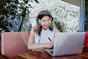 Young latin woman alone in home office or studing online with laptop, Mexican girl in Mexico studying at home photo