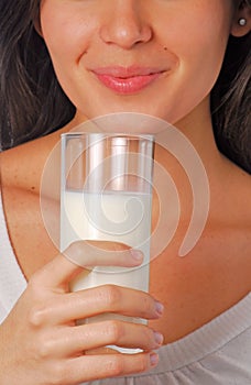 Young latin woman drinking glass of milk