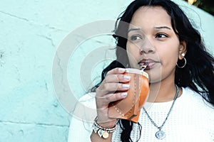 Young latin woman drinking traditional yerba mate tea.