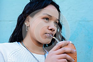 Young latin woman drinking traditional yerba mate tea