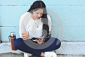 Young latin woman drinking traditional yerba mate tea with table