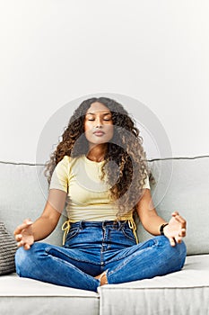 Young latin woman relaxed doing yoga exercise at home