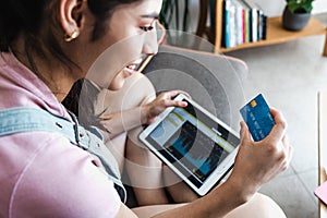 Young latin Woman reviewing online banking statistics in digital tablet at home in Mexico Latin America