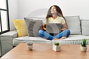 Young latin woman smiling confident using laptop at home