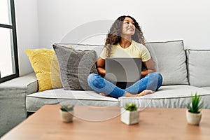 Young latin woman smiling confident using laptop at home