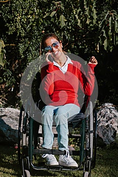 Young latin woman talking by phone in wheelchair at workplace in Mexico city