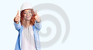 Young latin woman wearing architect hardhat approving doing positive gesture with hand, thumbs up smiling and happy for success