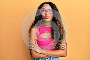 Young latin woman wearing casual clothes and glasses smiling looking to the side and staring away thinking