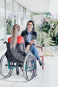 Young latin woman in wheelchair working with computer at workplace or office in Mexico city