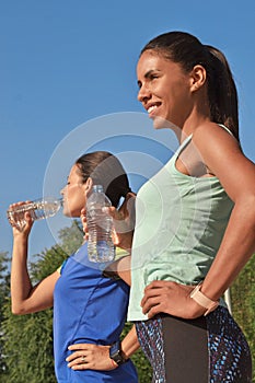 young latin women drinking water bottle after outdoors training