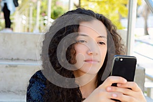 Young latin women sending message with smartphone.