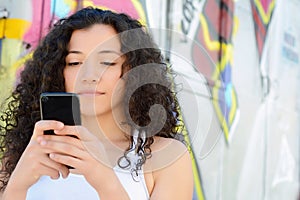 Young latin women sending message with smartphone.