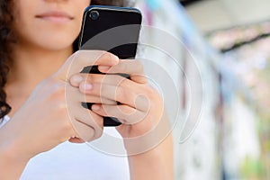 Young latin women sending message with smartphone.