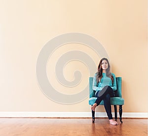 Young latina woman sitting in a chair