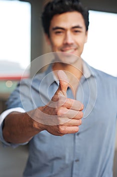 Young latino businessman holding thumbsup sign