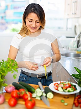 Young latino girl eating green salad to lose weight