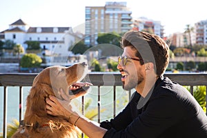 young latino man with sunglasses and beard and his brown golden retriever dog look at each other with love and affection. Concept