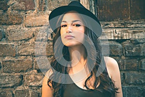 Young latino woman portrait with hat in front old house summer d