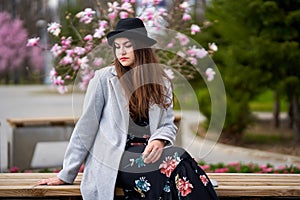 Young latino woman sitting on bench in the park