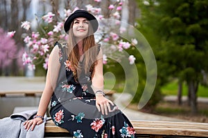 Young latino woman sitting on bench in the park