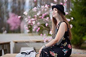 Young latino woman sitting on bench in the park