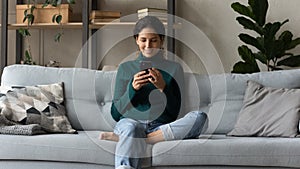 Young Latino woman use cellphone text online