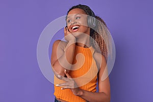 Young laughing ethnic African American woman in headphones stands in studio