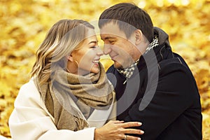 Young laughing man and woman hugging in the autumn park. Romantic couple on a date. Love and tenderness in a relationship. Close-