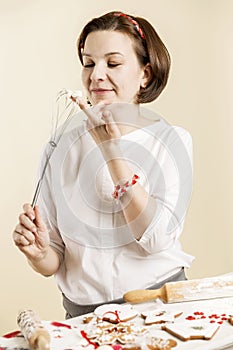 Young laughing woman bakes Christmas cookies for the holiday.