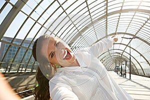 Young laughing woman taking selfie and pointing