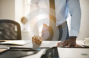 Young lawyer signing paperwork at his desk in an office