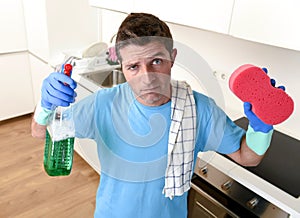 Young lazy house cleaner man washing and cleaning the kitchen with detergent spray bottle