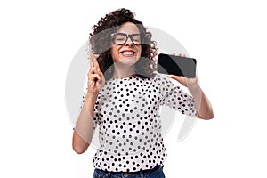 young leader woman with curly hairstyle dressed in summer blouse hopes to win online holding smartphone