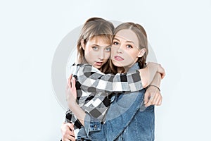 Young lesbian couple hugging and posing together isolated on blue