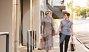 Young lesbian couple walking with shopping bags in the city