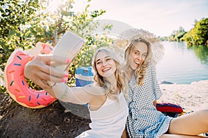 Young lesbian`s couple having fun and spending time at riverside in sunny day