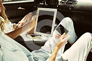 Young lesbian`s couple preparing for vacation trip on the car in sunny day