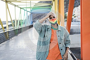 Young lesbian wearing LGBT rainbow flag pride mask - Focus on face