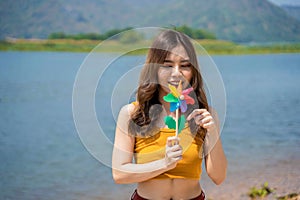 Young lgbt woman holding colorful turbine on the beach. Supporters of the LGBT community