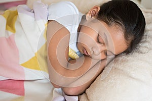 Young little asian girl sleeping lying on bed in her bedroom