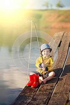 Young little boy fishing from wooden dock